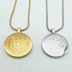 Gold and silver round atom pendants on matching chain necklaces (one gold, one silver).