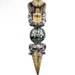 Ornate dagger pendant with a Buddha statue inside a turquoise-inlaid bead and gold blade with decorative filigree.