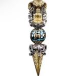 Ornate dagger pendant with a Buddha statue inside a turquoise-inlaid bead and gold blade with decorative filigree.
