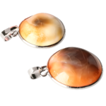 Two silver pendants with orange amber stones set in metal rings, shown against a black background