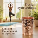 Copper tumbler in the foreground in a sunlit room, with a person practicing yoga in the background; French ad text reads 'Design ayurvédique' and 'Soutient l’immunité et la digestion.'